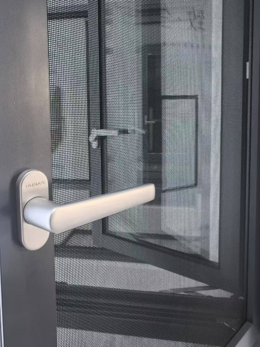 Close-up of a charcoal powder-coated screen panel with fine mesh and a satin metal lever handle
