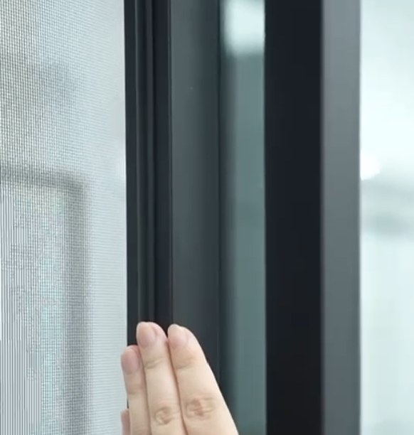 Fingertips on the mesh, the screen riding its own track
